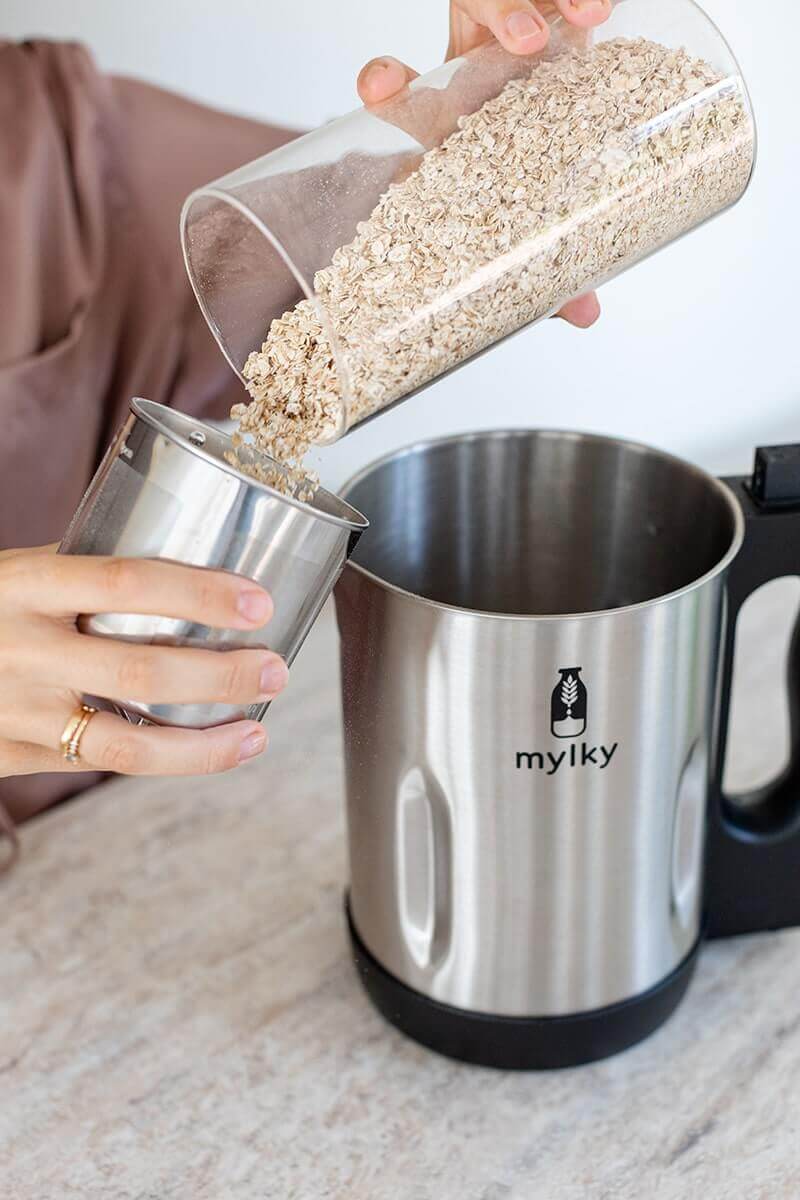 Versare l'avena nel filtro della macchina Mylky Blazing Skills per preparare il latte vegetale